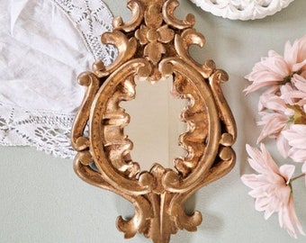 Antieke vergulde houten spiegel in de vorm van bloemen