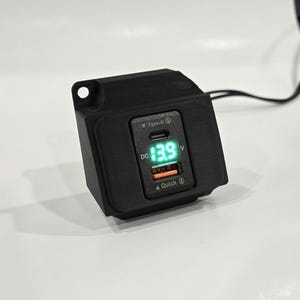 May include: Black car charger with a digital display showing 13.9 volts. The charger has a USB-C port and a Quick Charge port.
