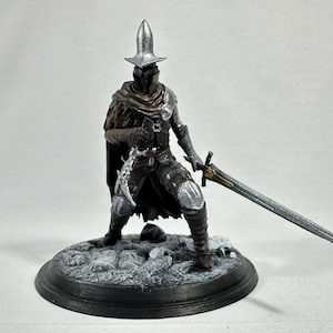Könnte beinhalten: Eine 3D-gedruckte Figur eines Ritters mit silbernem Helm und Rüstung, der ein Schwert hält. Der Ritter steht auf einem schneebedeckten Sockel.