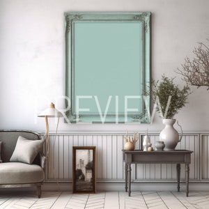 Könnte beinhalten: Eine weiße Wand mit einem hellblauen gerahmten Bild, ein graues Sofa mit einem weißen Kissen, eine Lampe, ein kleiner Bilderrahmen, ein Tisch mit einer Vase und ein paar Dekoartikeln.