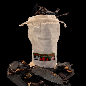 May include: A white drawstring bag filled with dried whole peppers, with a label that reads "Pisa de Salas Whole Pepper". Dark brown dried pepper pieces are scattered around the bag against a black background.