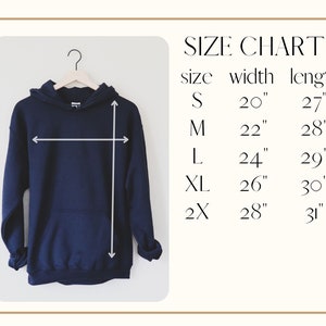 K&ouml;nnte beinhalten: Marineblauer Kapuzenpullover mit Fronttasche, an einem Holzb&uuml;gel h&auml;ngend. Das Bild enth&auml;lt eine Gr&ouml;&szlig;entabelle mit Ma&szlig;en in cm: S (51cm Breite, 69cm L&auml;nge), M (56cm Breite, 71cm L&auml;nge), L (61cm Breite, 74cm L&auml;nge), XL (66cm Breite, 76cm L&auml;nge) und 2X (71cm Breite, 79cm L&auml;nge).