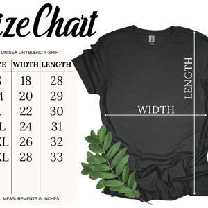 K&ouml;nnte beinhalten: Dunkelgraues Unisex-Dryblend-T-Shirt mit Gr&ouml;&szlig;entabelle. Die Tabelle listet die Gr&ouml;&szlig;en S bis 3XL mit den entsprechenden Breiten- und L&auml;ngenma&szlig;en in Zoll auf. Ein Zweig mit gr&uuml;nen Bl&auml;ttern befindet sich in der unteren rechten Ecke.