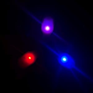 May include: Three glowing LED lights in red, blue, and purple against a black background. The lights are oval-shaped and emit a bright, diffused glow. The image has a dark, space-like aesthetic.