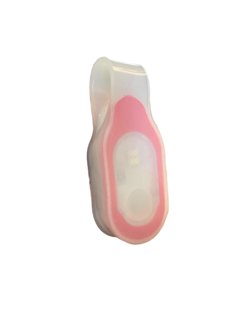 May include: A small, clip-on LED safety light. The light is encased in a clear, flexible material with a pink accent. The light has a white LED and a button. This safety light is designed to be attached to clothing or gear.