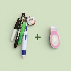May include: A collection of pens and a keychain with a floral design and the text "You got this." A pink LED clip-on light is also included. The items are arranged on a light green background.