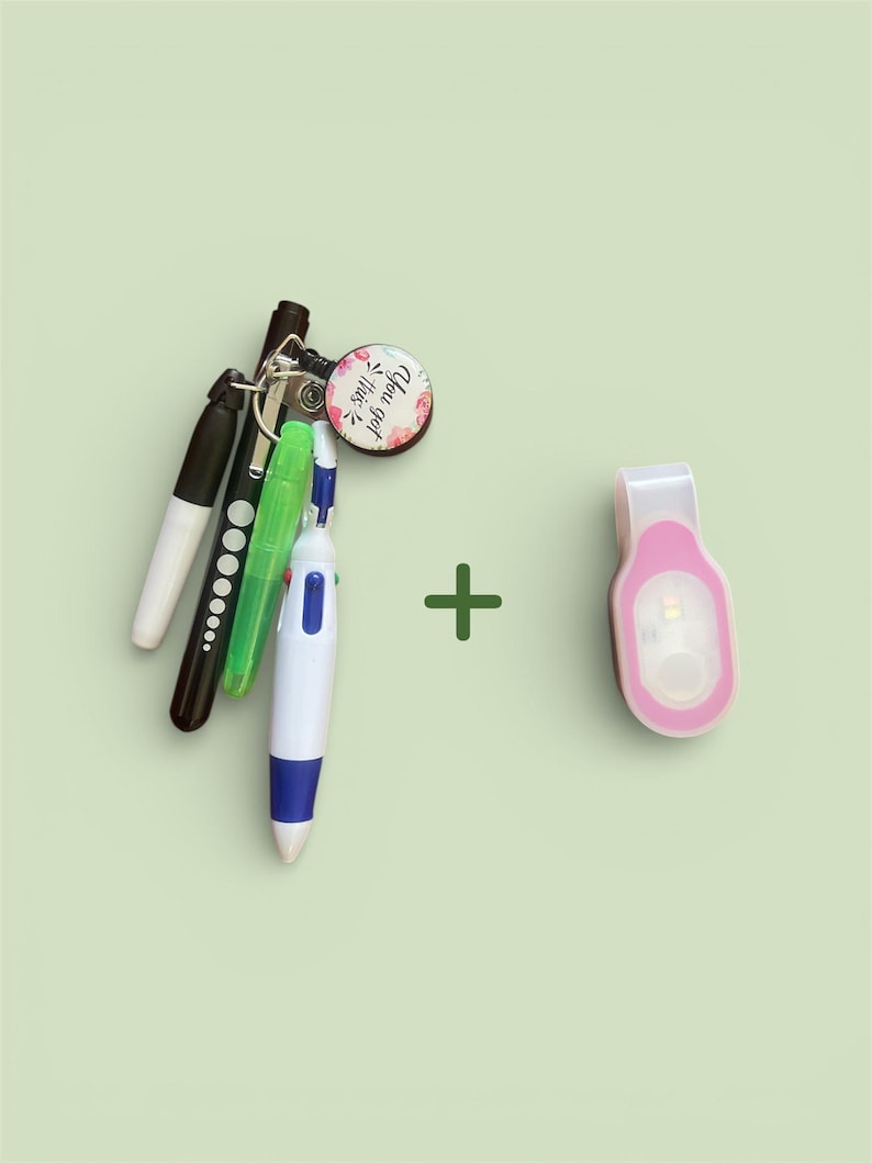 May include: A collection of pens and a keychain with a floral design and the text "You got this." A pink LED clip-on light is also included. The items are arranged on a light green background.