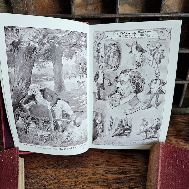 Puede incluir: Un libro abierto con ilustraciones de "Los papeles de Pickwick" de Charles Dickens. El libro presenta ilustraciones en blanco y negro de personas en varias escenas. El texto en la p&aacute;gina dice "Collins Clear-Type Edition of Dickens's Works."