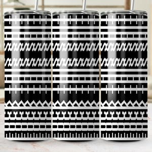 May include: Three stainless steel tumblers with a black and white geometric pattern. The design features horizontal stripes, zigzags, and other shapes. Each tumbler has a silver straw and a black lid. The tumblers are on a light-colored surface.