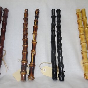 May include: Four pairs of wooden sticks, each pair is a different colour: brown, natural with brown accents, black, and natural with light brown accents.