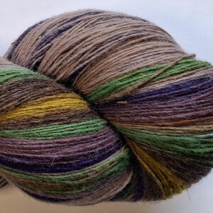 Wool yarn for knitting. High quality multicolor blue , green, grey striped 100 % wool yarn . Natural lanolin wool yarn.