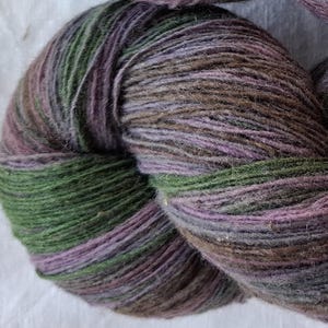 Filato di lana per lavorare a maglia. Filato di lana 100% multicolore di alta qualità, viola, verde a strisce. Filato di lana di lanolina naturale.