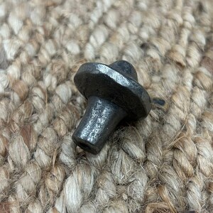 May include: A black metal cabinet knob with a round top and a cylindrical base.