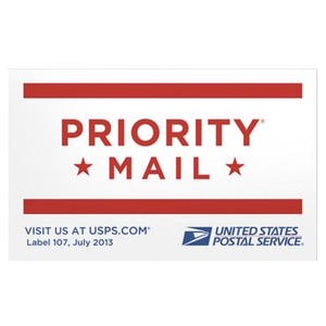 May include: A white rectangular label with red horizontal stripes at the top and bottom. The text "PRIORITY MAIL" is in red, with a star on each side. Below, it reads "VISIT US AT USPS.COM" and "UNITED STATES POSTAL SERVICE."