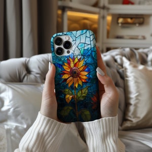 a woman holding up a phone case with a flower on it