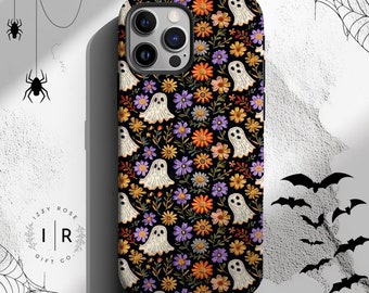 May include: Black phone case with a floral and ghost pattern. The case features a repeating design of white ghosts, orange, purple, and yellow flowers, and green leaves on a black background. The case has a camera cutout.
