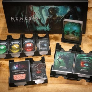 May include: A board game titled "Nemesis: Retaliation" with various card decks and black card holders. The cards are labeled with terms like "Item", "Exploration", "Attack", and "Serious Wound". The game box features a sci-fi illustration.
