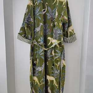 May include: A green velvet robe with a jungle print featuring zebras, leopards, and birds. The robe has a tie belt and long sleeves.