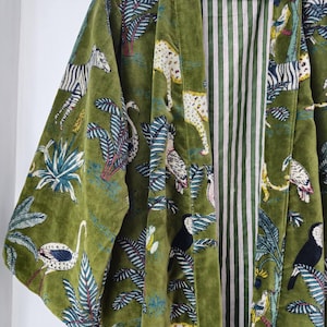 May include: A green velvet kimono with a jungle print featuring zebras, leopards, toucans, and palm trees. The kimono has a striped lining.