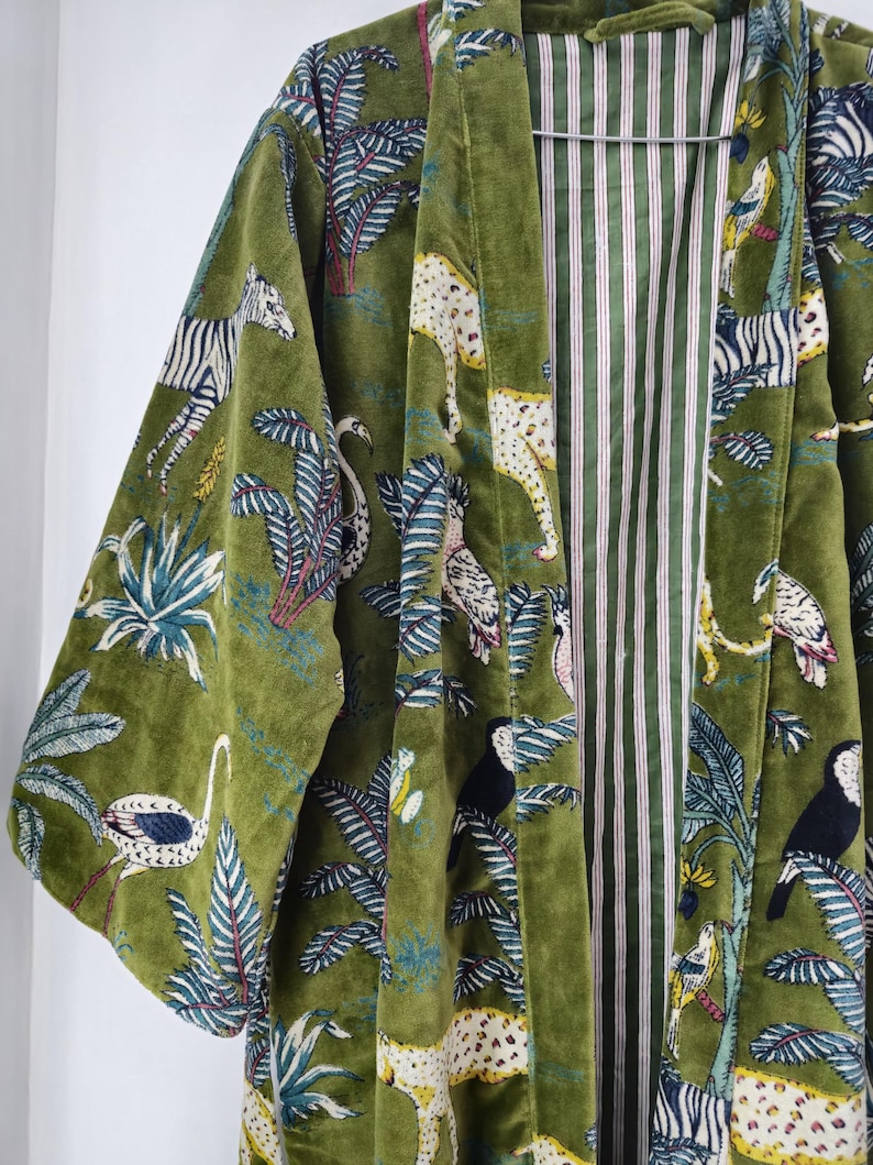 May include: A green velvet kimono with a jungle print featuring zebras, leopards, toucans, and palm trees. The kimono has a striped lining.