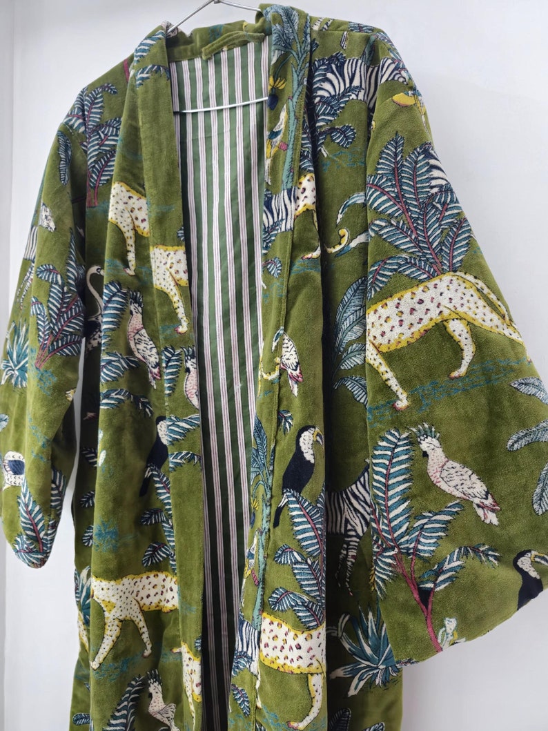 May include: A green velvet robe with a colorful print of zebras, leopards, toucans, and tropical plants. The robe has a striped lining.