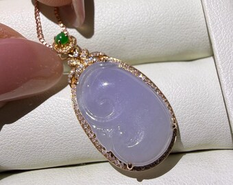 May include: A teardrop-shaped lavender jade pendant set in rose gold with a halo of small white diamonds. The pendant features a small green jade accent at the top and hangs from a delicate rose gold chain, showcasing a carved swirl design.