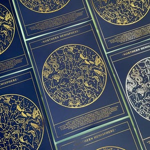 May include: Navy blue cards with gold foil constellation illustrations. Each card displays a circular star map with connecting lines and text. The words "Northern Hemisphere" are printed on the cards, with a list of constellations.