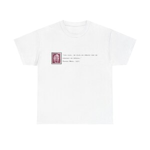 Könnte beinhalten: Weißes T-Shirt mit einem Briefmarken-Design mit einem Porträt und deutschem Text. Der Text enthält ein Zitat von Thomas Mann, 1951. Das T-Shirt hat einen klassischen Rundhalsausschnitt.