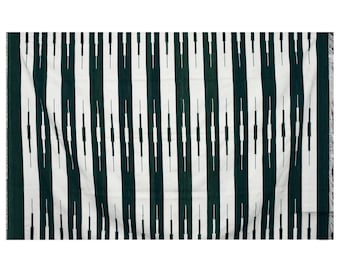 May include: A white and dark green woven throw blanket with a geometric pattern. The pattern features vertical stripes with a series of small, horizontal lines.