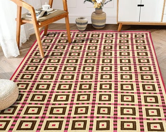 Könnte beinhalten: Ein beige-brauner gewebter Teppich mit einem geometrischen Muster in Rosa und Braun. Der Teppich hat ein kariertes Design mit Quadraten unterschiedlicher Größe.