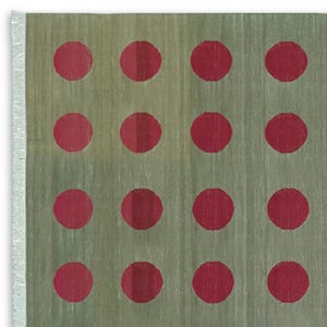 Puede incluir: Una alfombra verde con un patrón de círculos rojos.