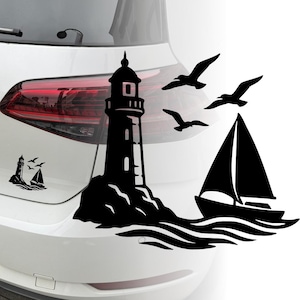 Può includere: Adesivo in vinile nero raffigurante un faro su una costa rocciosa, una barca a vela e tre gabbiani in volo. Il design è applicato su un'auto bianca, con il fanale posteriore visibile.