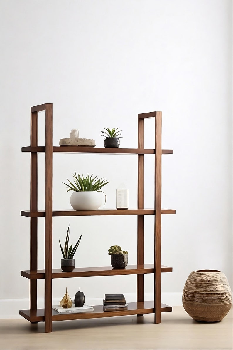 May include: A dark brown wooden bookshelf with four shelves, displaying various decorative items and potted plants. A large woven vase sits to the right. The shelves hold a variety of small plants, sculptures, and books.