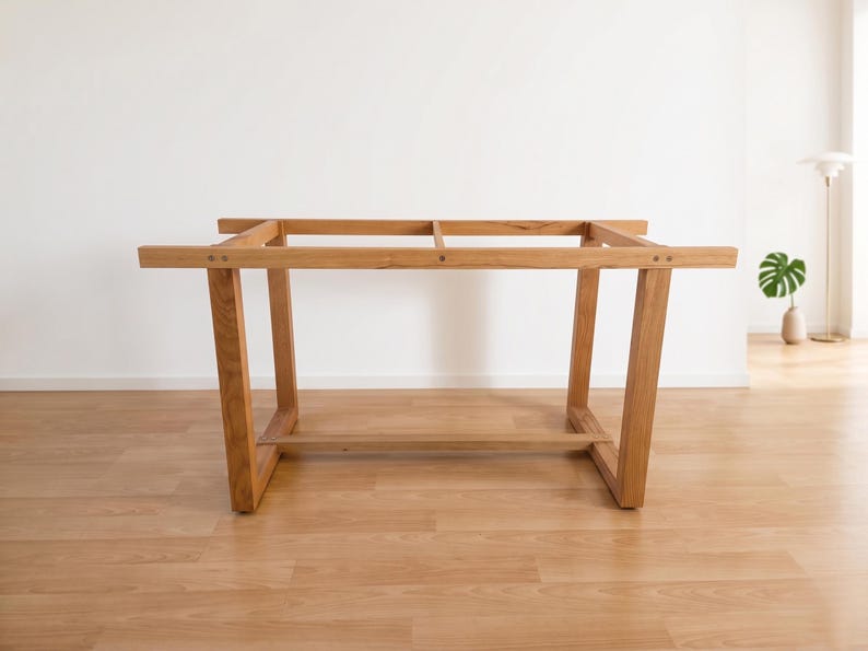 K&ouml;nnte beinhalten: Hellbraunes Holz-Tischgestell mit rechteckiger Oberseite und abgewinkelten Beinen. Das Tischgestell ist aus Massivholz gefertigt und hat ein schlichtes, modernes Design. Das Tischgestell ist ca. 152 cm lang und 76 cm breit.