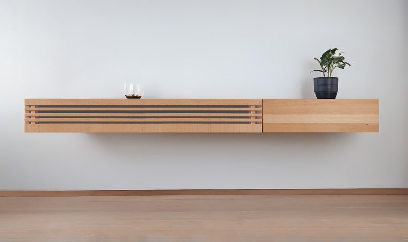May include: A light wood wall mounted shelf unit with a slatted front and a solid wood side panel. A small potted plant sits on the top of the shelf.