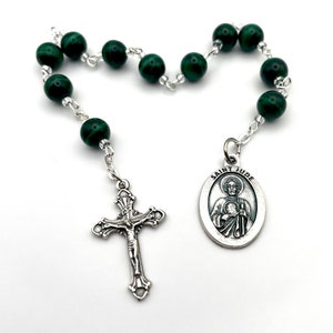 Könnte beinhalten: Eine grüne Malachit-Rosenkranz mit einer silbernen Heiligen-Judas-Medaille und einem silbernen Kruzifix.