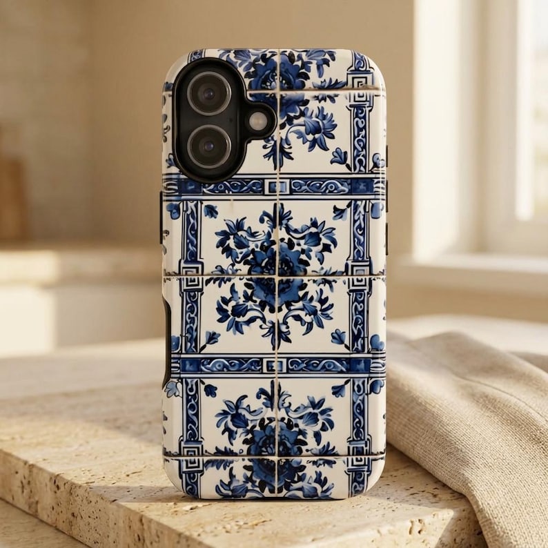This phone case features a classic Portuguese azulejo-inspired tile pattern in deep cobalt blue and soft white tones. The design mimics hand-painted ceramic tiles arranged in a geometric grid, giving it an elegant old-world Mediterranean feel. Delicate floral motifs and ornamental borders create a timeless aesthetic reminiscent of coastal villas, antique ceramics, and traditional European craftsmanship.