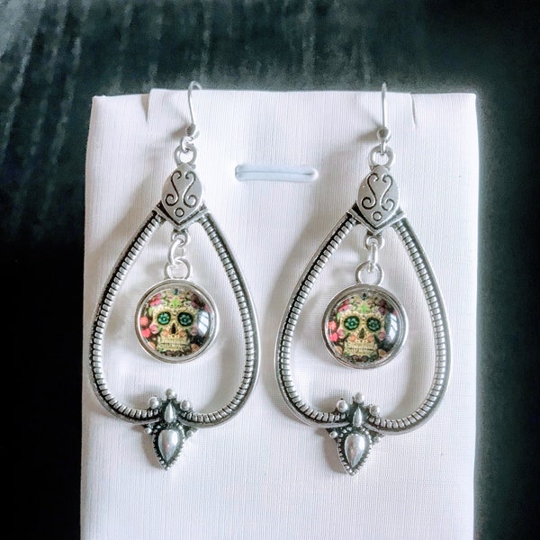 Grandes boucles d'oreilles avec magnifique pendentif style bohème et cabochon en verre image tête de mort mexicaine.