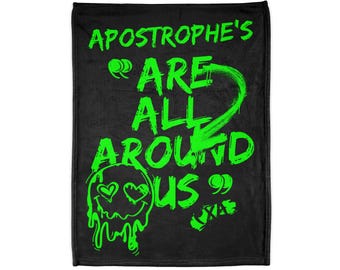 May include: Black blanket with the neon green text "APOSTROPHE'S ARE ALL AROUND US" and a dripping skull graphic with heart eyes. The blanket is rectangular and appears to be made of a soft material.