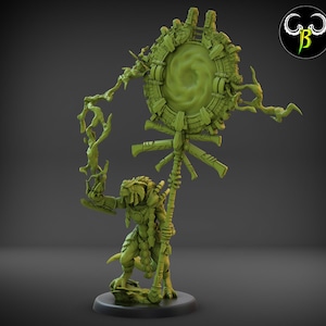 May include: A green plastic miniature figurine of a reptilian humanoid holding a staff with a circular, glowing portal at the top. The portal is surrounded by intricate details and the staff is adorned with carvings.