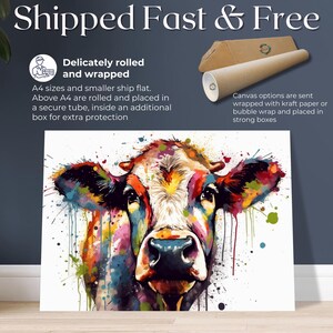 May include: A colorful abstract painting of a cow's face with splashes of paint in the background. The painting is on a white canvas.