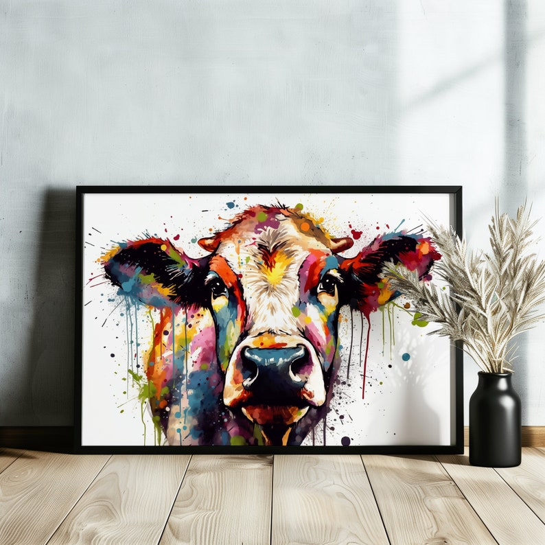 May include: A colorful watercolor painting of a cow's face. The cow is painted in shades of red, orange, yellow, green, blue, and purple. The background is white with splatters of paint.