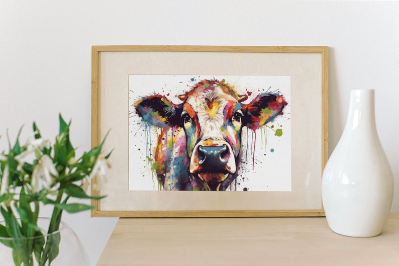 May include: A colorful watercolor painting of a cow's face with splashes of paint in the background.