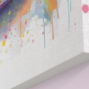 May include: A canvas print featuring a colorful watercolor painting. The artwork showcases a vibrant mix of colors, including pink, yellow, orange, and blue, with paint drips and splatters. The canvas has a textured surface and is wrapped around a wooden frame.