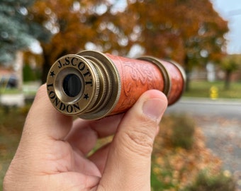 May include: A brass telescope with a brown leather covering. The telescope has a lens with a black circle in the centre and the words "J. SCOTT LONDON" engraved on the side.