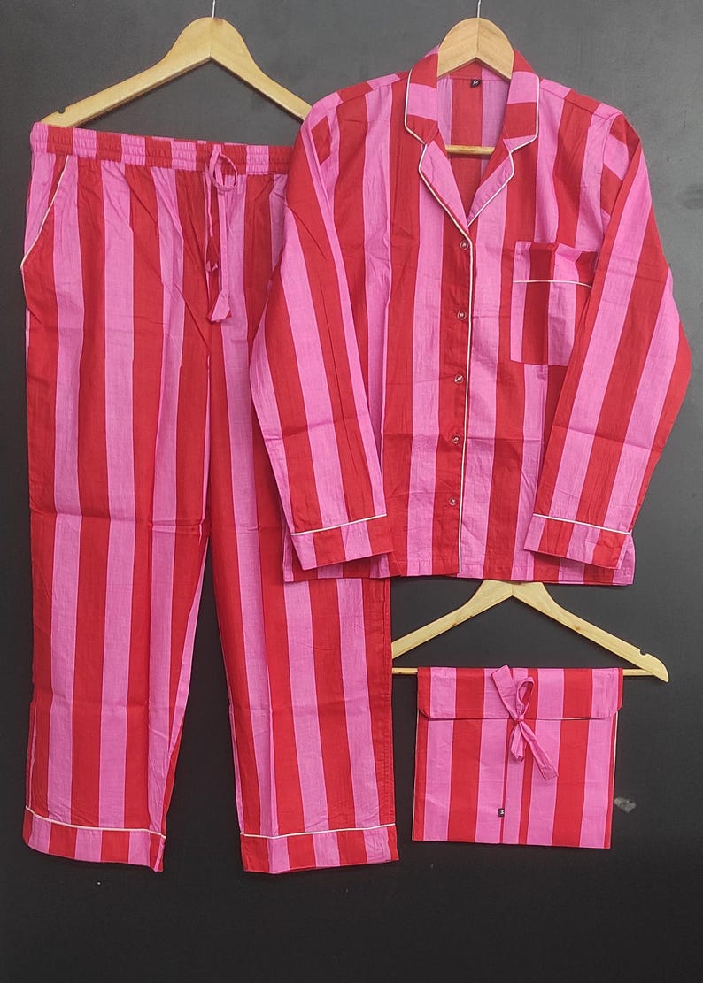 K&ouml;nnte beinhalten: Ein rot-wei&szlig; gestreiftes Pyjama-Set mit einem lang&auml;rmeligen Oberteil und einer Hose. Das Set hat einen Knopfleisten vorne und einen Kordelzug in der Taille.