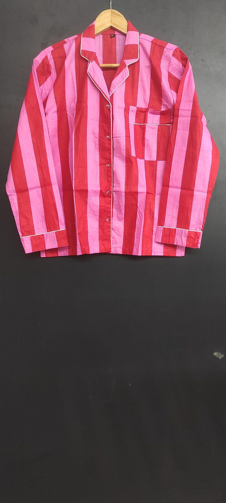 K&ouml;nnte beinhalten: Ein lang&auml;rmliges Hemd mit rosa und roten Streifen, wei&szlig;em Kragen und Knopfleiste.