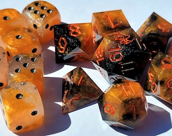May include: A set of ten orange and black dice with black and white speckled accents. The dice are made of resin and have a variety of shapes and sizes.