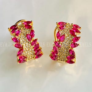 Puede incluir: Un par de pendientes de oro con un racimo de piedras rosas en forma de marquesa y piedras redondas transparentes.