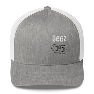 May include: A heather grey baseball cap with a white mesh back. The front panel features the white embroidered text "Deez" positioned above a black line-art graphic of two hexagonal metal nuts, centred on the crown of the structured hat.